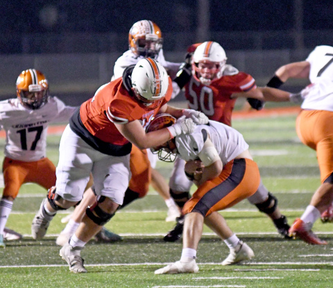 Gage Griffith wrestles Lexington's ballcarrier to the ground in Aurora's 47-7 win over the Minutemen Friday. 