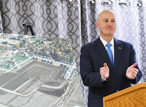 Gov. Pete Ricketts congratulated Aurora community leaders Friday for demonstrating the leadership and cooperation necessary to take advantage of the state’s Rural Workforce Housing Fund to launch a 64-lot housing development. Behind Ricketts is a large aerial photo of the Streeter Subdivision, where infrastructure work has already begun.