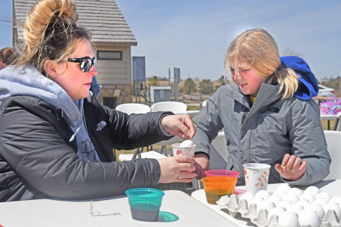 Natasha Kolbet helps daughter Lilyauna dye an egg at Pioneer Trails this weekend.