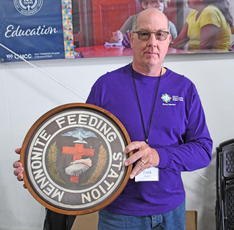 MCC Board President Frank Steckley displays one of eight plaque honoring Ukraine residents, which sold for more than $9,000 during Saturday’s MCC Relief Sale at the fairgrounds.
