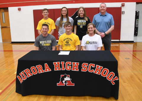 Aurora senior Caden Carlson, front center, signed his letter of intent April 22 to continue his pole vaulting career at Wichita State University. Pictured with him are, front row: parents Chad and Yvonne Carlson. Back from left: siblings Ryan, Kyla and Jenna Carlson, as well as head track coach Gordon Wilson.