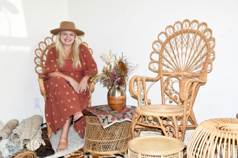Triniti Jensen, owner of Trin Jensen Photography in Aurora, poses on the other side of the camera for a change, sitting amongst boho pieces she now offers for rent as part of her side business, called The Bohemian Hatter.