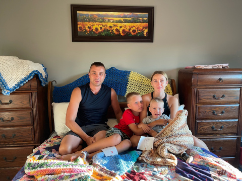 Valeriy, Kyril, Tatiana and Danial lay out their quilts and prayer shawls received from Aurora United Methodist Church. The family moved to Nebraska in mid-July as refugees from Odessa, Ukraine.