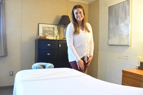 Madison Berthelsen poses behind her massage table in her new office at The Leadership Center. Berthelsen offers massages, facials, waxing and will soon teach yoga classes at Tri-Fit.