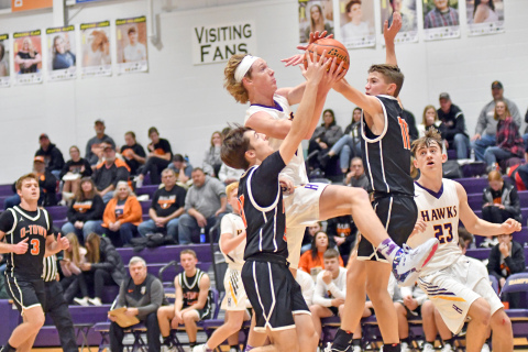 Hampton’s Brayden Dose drives the lane between two Osceola defenders during the Hawks’ 64-47 loss to the Bulldogs at home Friday. 