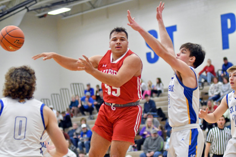 Aurora’s Carlos Collazo dishes a no-look pass during the Huskies’ 64-30 win at St. Paul Saturday.
