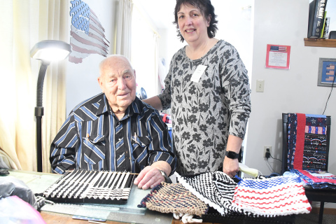 Ramer Fassnacht with his daughter Teresa Elder-Smith and completed hot pad holders, with one in progress, on the table at his apartment in East Park Villa. Fassnacht makes up to 20 a week and his daughter helps finish them and works with her two sisters to sell his creations.