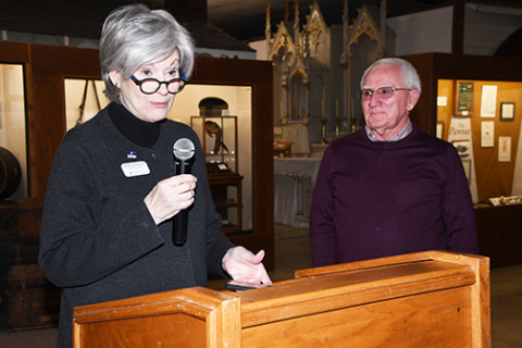 Representative of the Board of Trustees of History Nebraska Katherine Endacott delivers a presentation on volunteer Bob Cool at her right. Cool was recognized by the organization for spending 13 years and thousands of hours helping the museum in the preservation of local history.