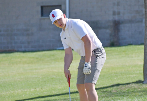 Luke Grosshans watches his putt on the par-3 4th hole trickle back down toward the hole as the wind whips the flag around on the ground at the York Invite Thursday. Grosshans carded an 80 for his first varsity medal. 