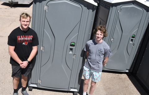 Karson, left, and Caden Meyer stand next to some of their 18 porta potties that can be rented out from their business, C and K Potties. The two high schoolers started the venture this year and have already found success with construction companies and providing for events.