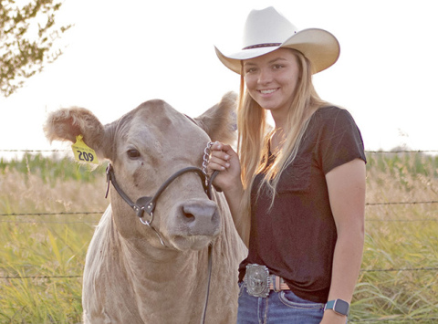 Artificial insemination tecnician Emma Snoberger stands with one of her show cattle. The cow has produced one calf through the use of AI calf and is currently AI bred.  