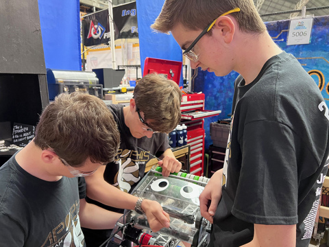 Members of the Apophis robotics team, which includes members from Aurora and Arkansas, work on their robot, Choppy, during worlds competition recently in Houston.