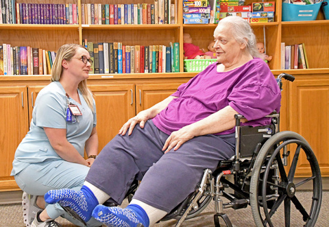 Westfield Quality Care LPN Chrissie Logston, left, talks with resident Linda Hecht at the facility in Aurora. Over the past year the skilled-care facility has directly hired more local nurses and aides, reducing its dependence on more expensive staffing agency personnel.