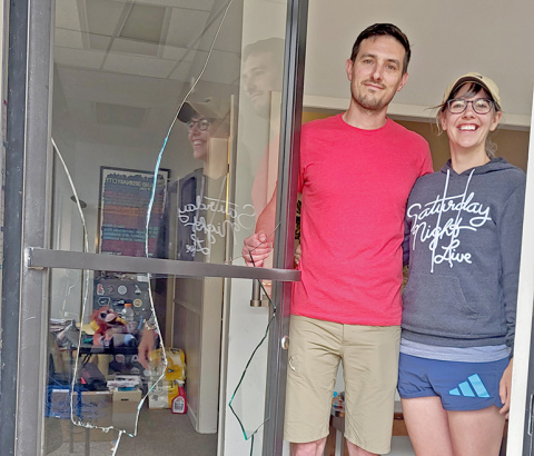 Mitchell and Sarah Lyon show the front door of their office on the square that was broken out Friday by a young deer that had crashed through the back window in the alley before 7 a.m.