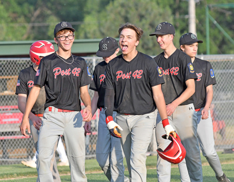Jace Dorsey (middle) and his teammates celebrate after erasing a 9-0 deficit to defeat Twin River 12-11 at Mitchell Field June 7. 