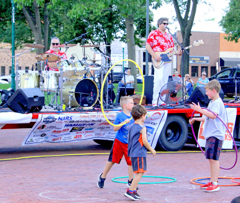 A group of boys make creative play using the hula hoops on the street in front of the bandstand at Friday’s opening night of Bands on the Bricks on the Aurora town square. Ricky Lee and the Fabulous 50s opened the 2023 season of the popular summer festival.