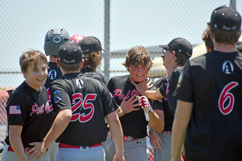 Collin Stolpe touches helmets with coach Jarrett Havens, pictured right, before being mobbed by his teammates at the plate after his third inning home run in a 20-14 loss to York Monday in the B-1 area tournament. 