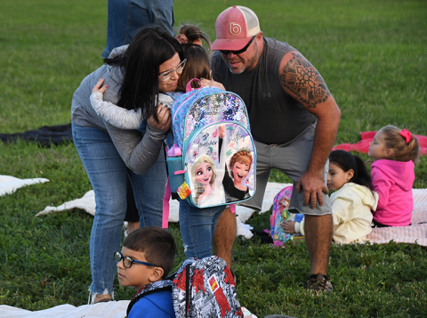 Erin Akerson gives a teary embrace to her daughter, Millie, while father Steve looks on. 