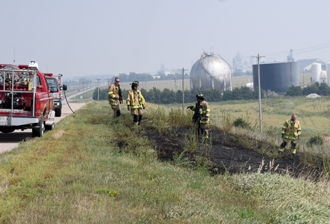 Aurora firefighters inspect the burned grass just off Hwy 34.