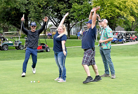 Tiffany Luebbe sunk a putt during Friday’s MCHI golf benefit, setting off a celebration amongst team members, from left: Dalton Chasting, Eric Smith and Chris Hyde.