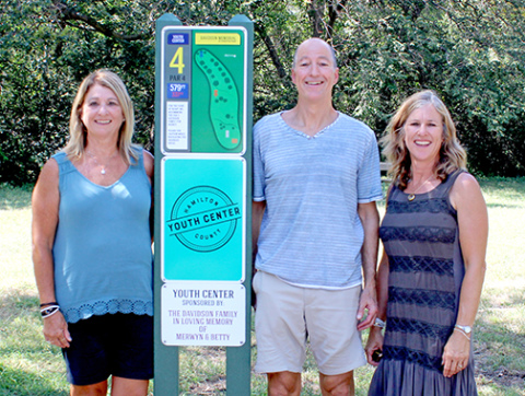Lila Wolf of Aurora and her siblings, Mark Davidson of Lawrence, Kan. and Sharon Harthoorn of Norfolk stand at the tee pad for Youth Center hole of the Merwyn and Betty Davidson Memorial Disc Golf Fitness Trail on Sunday afternoon. The newly completed course in Streeter Park is named after their parents. 