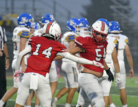 Kellen Peterson (54) high fives Canon Allen during Aurora's 42-6 Homecoming win over St. Paul.