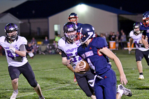 Hampton’s Bryce Joseph (44) and Tyler Mollevik (52) give chase during the first half of the Hawks’ 77-20 win at Heartland Lutheran Thursday. 