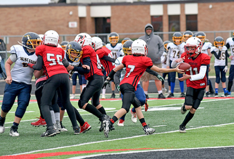Aurora QB Zachary Seim hands the football to Bryce Peterson on a jet sweep.