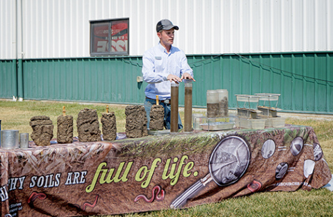 USDA NRCS State Soil Health Specialist Aaron Hird gives a practical demonstration at the field day event. The demonstration shows the soil structure of samples from no-till and conventionally tilled fields. 