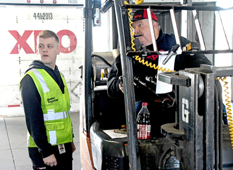 Erik Holloway, pictured at left, utilizes some of the logistics training he received in the US Army in his new job as a freight operations supervisor at XPO in Aurora.
