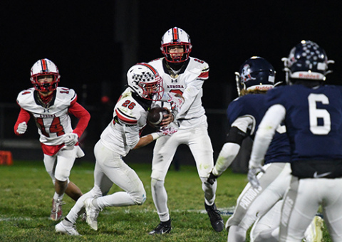 Quarterback Booker Scheierman hands off to Maddex Egger on a night where yards were hard to come by for both teams.