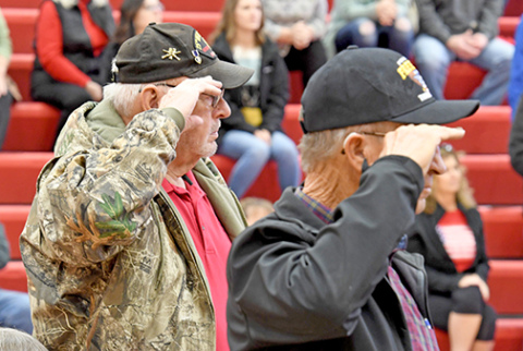 U.S. Army veterans salute as the  Army Song is played by the Aurora High School Band at Friday’s Veterans Day program at the high school. 