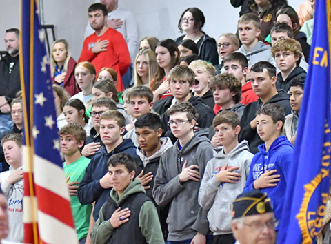 Students at High Plains Community Schools stand at attention as members of the American Legion post the colors.