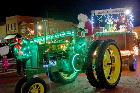 Jay and Christie Schulze pulled Santa’s Workshop through the downtown square Saturday night, one of 16 entries in the Come Home to Christmas lighted tractor parade. 