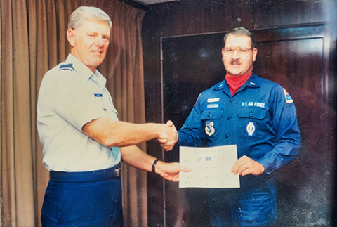 In a photo taken in 1989 during his days of serving in the U.S. Air Force, David Feddern, right, is presented with a certificate recognizing his participation in the launch of a Minuteman III ballistic missile on July 11.