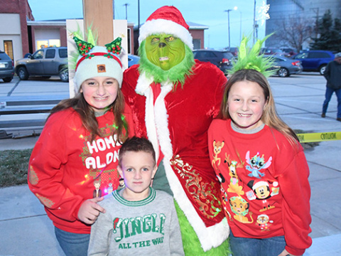 The Bodee children cozy up to the Grinch for a photo Sunday evening in Hampton. From left are Blaklee, Bentlee and Brinlee Bodee.