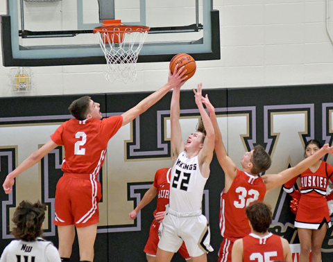 Aurora’s Booker Scheierman swats the shot of Dawson Urbanski as part of the Huskies’ 45-40 win on the road Saturday. Scheierman blocked two shots in the game. 