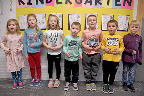 The seven members of Hampton’s kindergarten class demonstrate Santa’s trademark “HO, HO, HO” laugh as they stand in front of their Christmas bulletin board. From left are Grace Winfield, Josie Herman, Anniston Arnett, Carter Klute, Bodee Conard, Eelix De La Cruz and Axel Fisher. 