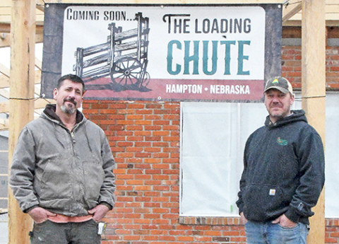 Hampton residents Ryan Bamesberger, left, and Grant Dose, representing two of the three couples involved in starting the Loading Chute restaurant and bar, stand outside the former Hampton Legion Hall which is being transformed into a new hometown cafe for the village. 