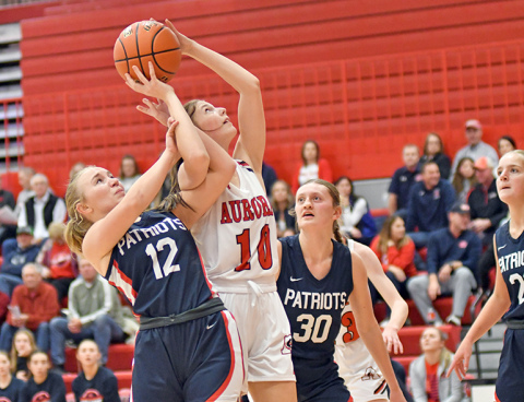 Kenna Merrihew gets twisted up with multiple defenders in the paint during Aurora’s 58-34 loss to Adams Central Thursday. 