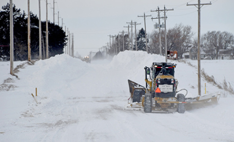 Two motor graders equipped with v-plows continue to work Monday afternoon to open up a two-mile stretch of 12 Road just west of Aurora. The process had started at 7 a.m. and by 1:30 p.m. only a one lane track had been cleared. 