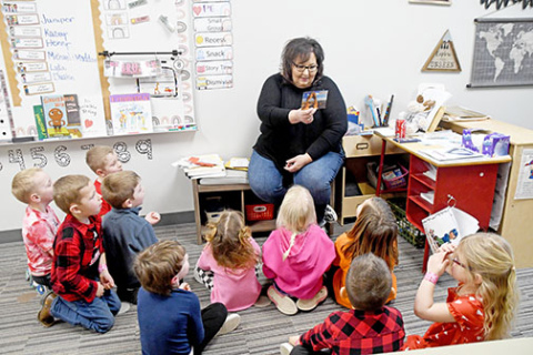 Giltner preschool teacher Amy Wilson shows her students a postcard received from Arizona as part of the ‘Valentines Across the Country’ project she started.
