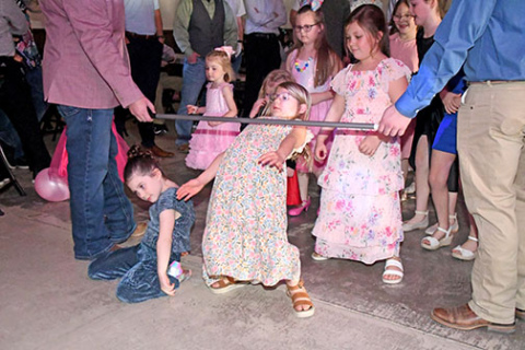 The limbo was one of the many dances the girls got to participate in Sunday night at the Daddy/Daughter Dance. Here Macie High (center) shows how low she and her friends can go.