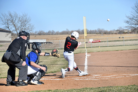 Aurora’s Keelan Phillips pulls the baseball down the line during the Huskies’ 13-3 loss at Centennial last week in the program’s first-ever high school game. 
