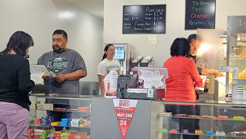 Volunteers from Ramon’s Tile work the concessions stand at 12th Street Cinema on a recent weekend. 