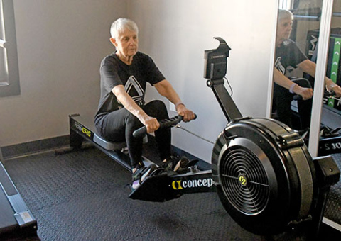 Marsha Mills works out at Tri-Fit in Aurora as part of her recovery from surgery to remove a massive brain tumor. Contrary to doctors’ predictions, she has regained her ability to walk and is now working on getting strength back in her left arm.