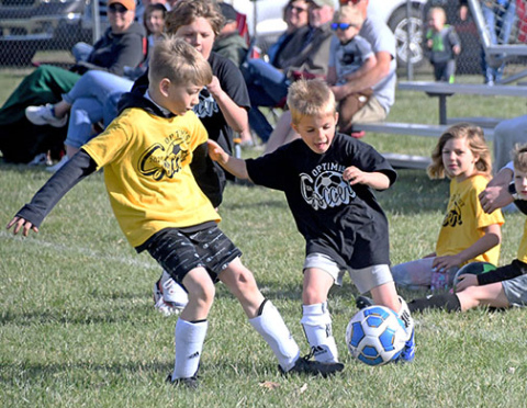 Titus High (right) fights for the ball against opposing player Dawson Bartek. 