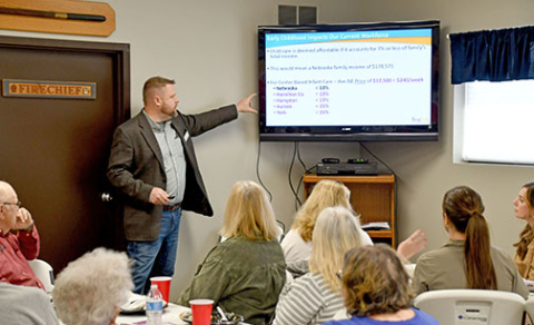 Mike Feeken of First Five Nebraska shows a slide to point out that Nebraska families spend on average 13 percent of their income on child care. He said 7 percent of household income is considered affordable when it comes to daycare. Feeken’s presentation was part of two public meetings held in Hampton last Wednesday to discuss the impact of affordable and dependable child care on a community. 