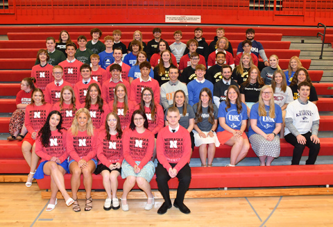Aurora seniors pose displaying t-shirts indicative of their post-grad plans.