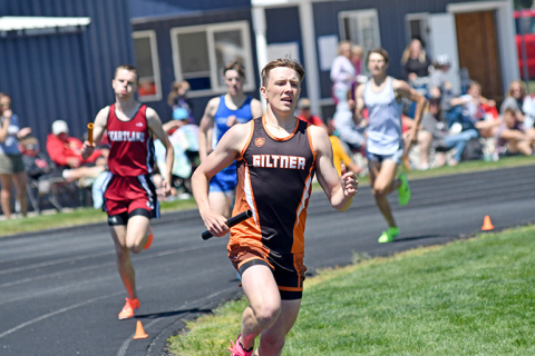 Phillip Kreutz rounds the first turn on the final lap with the field chasing him as the Hornet senior led the 3200 relay group to a win at the D-6 district in Kenesaw. 
